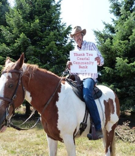 Man on horse holding sign that reads, 